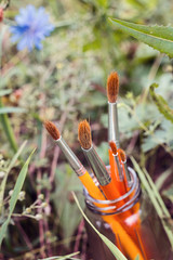 Paintbrushes in bank on a background of grass