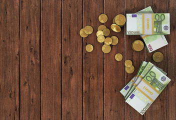 Money: euro coins and bills close up isolated on wood background