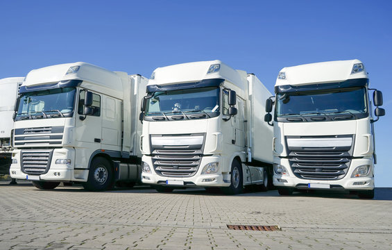 Spedition - Logistik, drei geparkte weiße Lastkraftwagen 