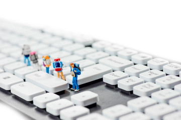 Miniature backpackers on top of the keyboard.