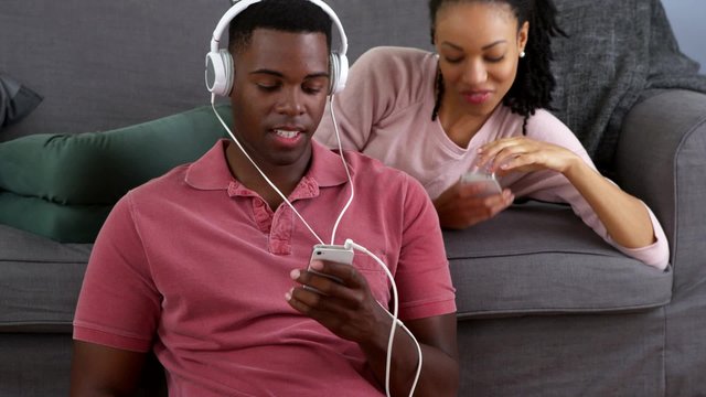 African American couple listening to music and taking picture with smart phones