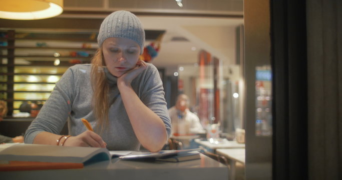 Woman Making Notes in Notebook