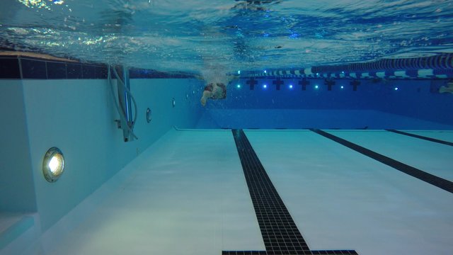 Underwater pool shot man swimming breastroke laps