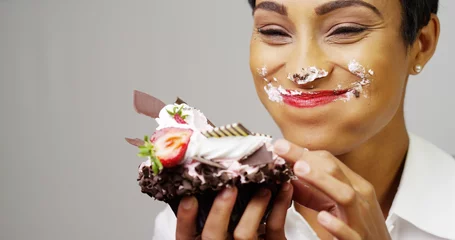 Fotobehang Zwarte vrouw maakt er een zooitje van en eet een enorm luxe dessert © rocketclips