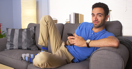 Attractive Mexican man lying on couch