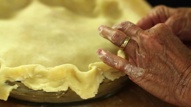 a woman shaping a pie crust