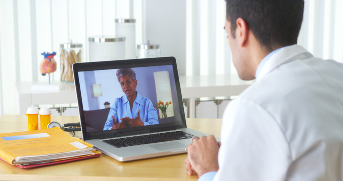 Mexican doctor video chatting with mature patient