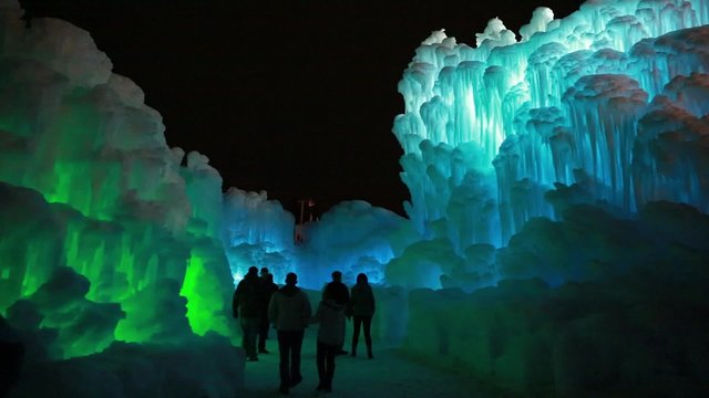 people walking through frozen ice castle