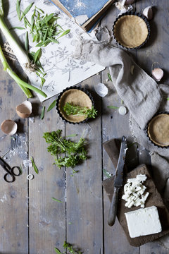 Preparation of little quiche with fresh ingredients on wooden rustic surface