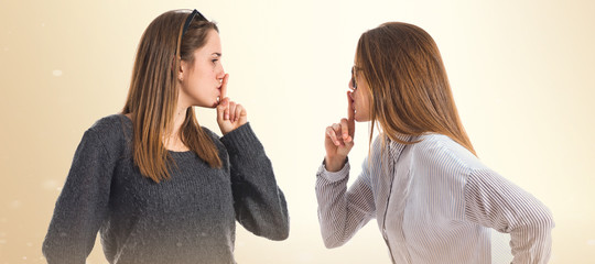 Twin sisters making silence gesture