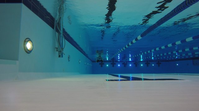 Underwater low shot of man swimming in clean swimming pool