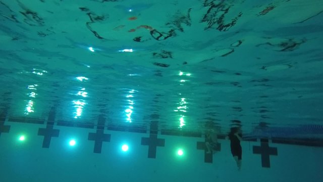 Slow motion of boy diving jumping into pool underwater shot