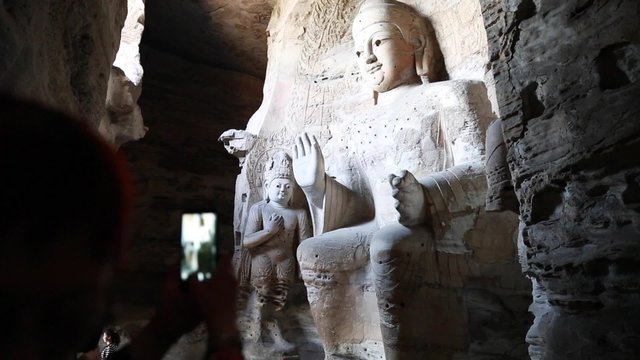 tourist taking pictures at the yungang grottoes in datong china