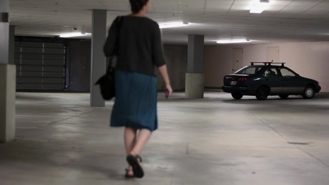 Woman walks through empty parking garage