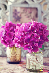 belles fleurs d& 39 hortensia violet dans un vase sur une table.