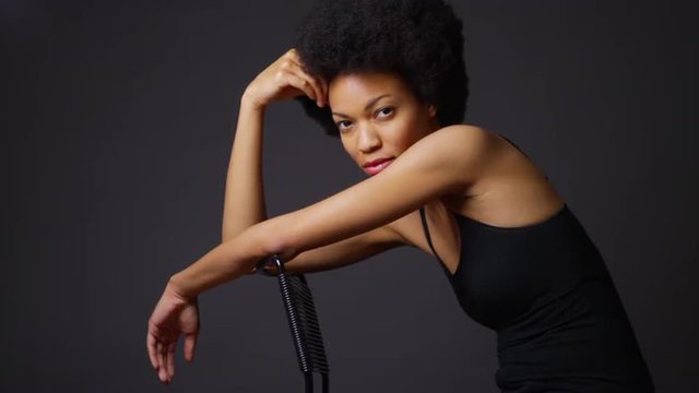 Black woman deep in thought sitting in chair