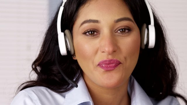 Happy Mexican businesswoman talking with headset