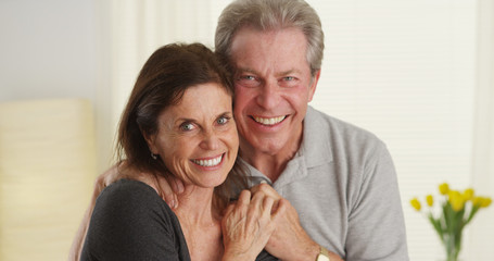 Cute senior couple smiling and looking at camera