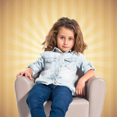 Fototapeta na wymiar Blonde cute girl sitting on little armchair