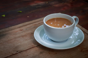 Cup of hot coffee  on wood board