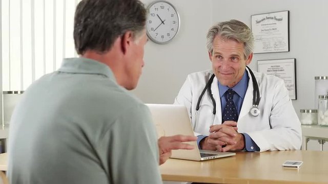 Senior doctor listening to mature patient