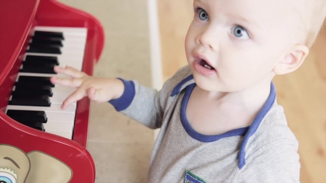 a toddler playing the piano