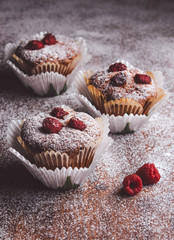 Muffins on a wooden table covered with sugar.