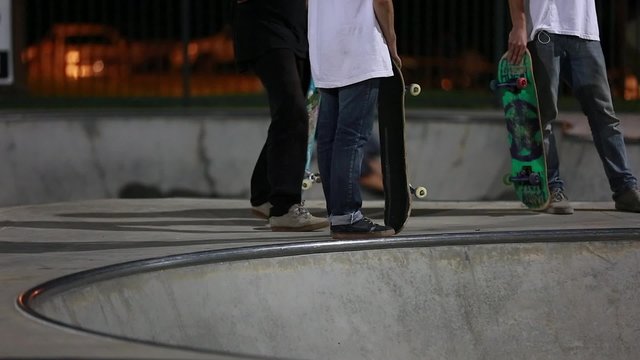 teen skateboarders at skate park night