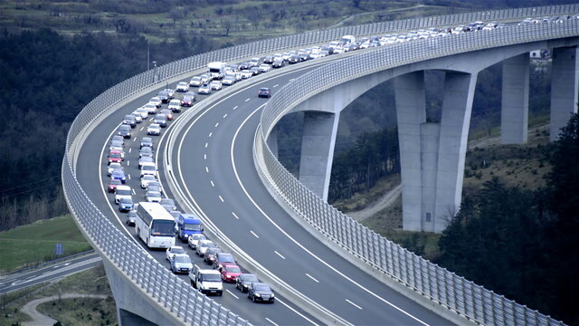 Long line of vehicles on highway bridge at evening