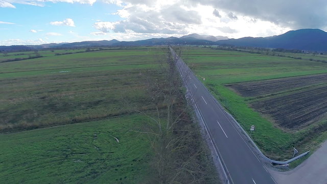 Aerial shot of straight road through countryside