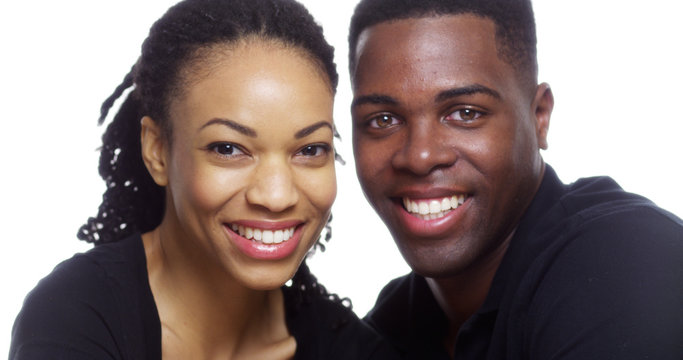 Happy smiling young black couple looking at camera on white background