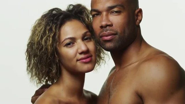 Attractive black couple standing and smiling at camera