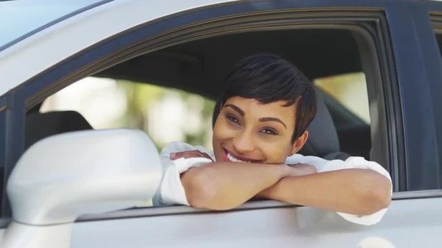 Black woman smiling and looking out of car window