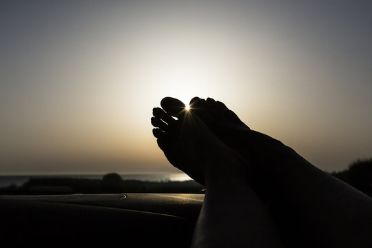 Feet on dashboard, driving on empty road on vacations, near the