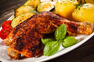 Barbecued chicken leg with boiled potatoes and vegetables 