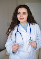 Portrait of young woman doctor on white coat standing in hospital