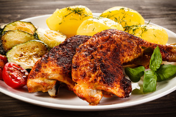 Barbecued chicken leg with boiled potatoes and vegetables 