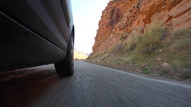 A cool low exterior shot of car driving in desert