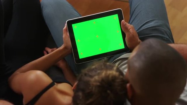 African couple holding tablet with greenscreen