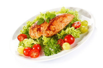 Roast chicken fillet and vegetables on white background