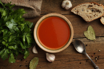 Tomato cream soup with ingredients on wooden background. Top vie