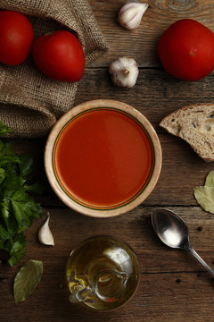 Tomato cream soup with ingredients on wooden background. Top vie