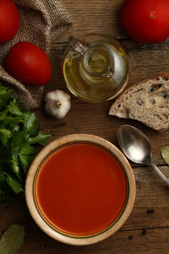 Tomato cream soup with ingredients on wooden background. Top vie