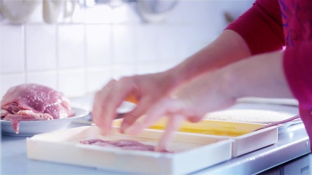 Putting Meat in Flour Ingredients to make Wiener Schnitzel