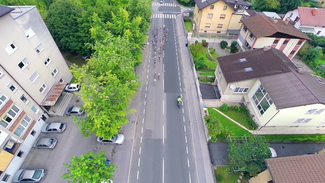 Aerial following group of cyclists on street