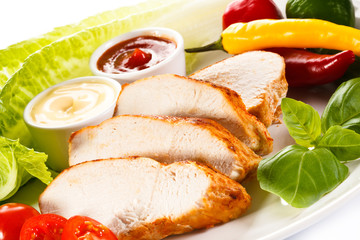 Roast chicken fillet and vegetables on white background 