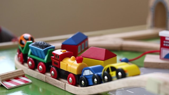 a toddler playing with toy trains and cars on track