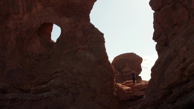 Man taking picture under arch in arches national park