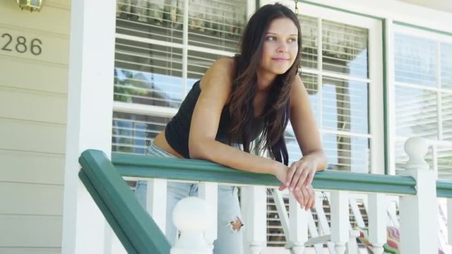 Hispanic woman leaning on rail smiling