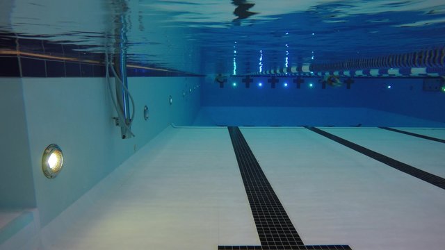 Underwater shot man swimming backstroke in a pool